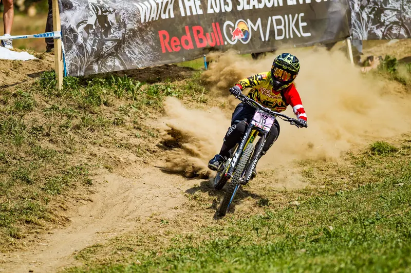 Rider in curva sotto lo striscione Red Bull ai Mondiali di Downhill in Val di Sole