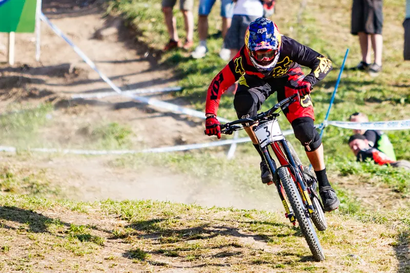 Rider di downhill in salto sul tracciato della Val di Sole