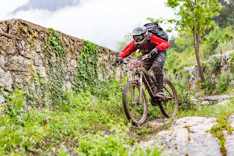 Rider in mountain bike tra rocce e vegetazione a Terlago