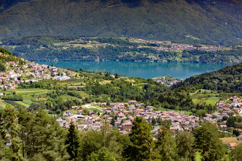 Lago alpino e paesi della valle visti dall'alto